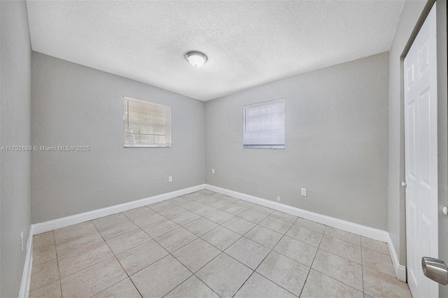 2821 N 74th Ave, Hollywood, FL 33024 - empty room featuring light tile patterned floors, a textured ceiling, and baseboards