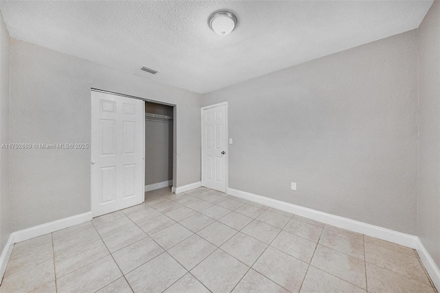 2821 N 74th Ave, Hollywood, FL 33024 - unfurnished bedroom with a textured ceiling, baseboards, light tile patterned flooring, and a closet
