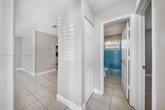2821 N 74th Ave, Hollywood, FL 33024 - hallway with light tile patterned floors, a textured ceiling, and baseboards
