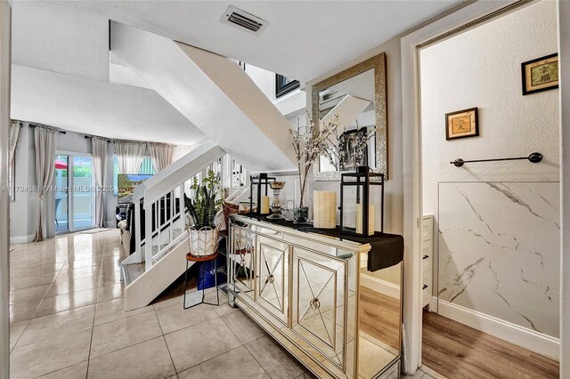 interior space with visible vents, baseboards, and stairway