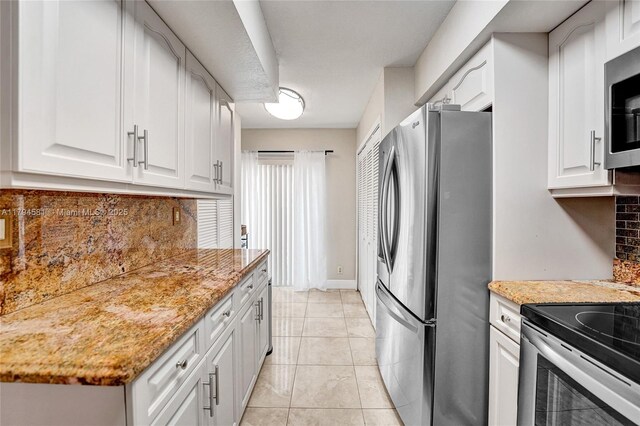 kitchen featuring light stone counters, white cabinets, stainless steel appliances, and tasteful backsplash