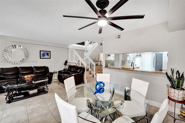tiled dining area featuring stairway, ceiling fan, a sink, and visible vents