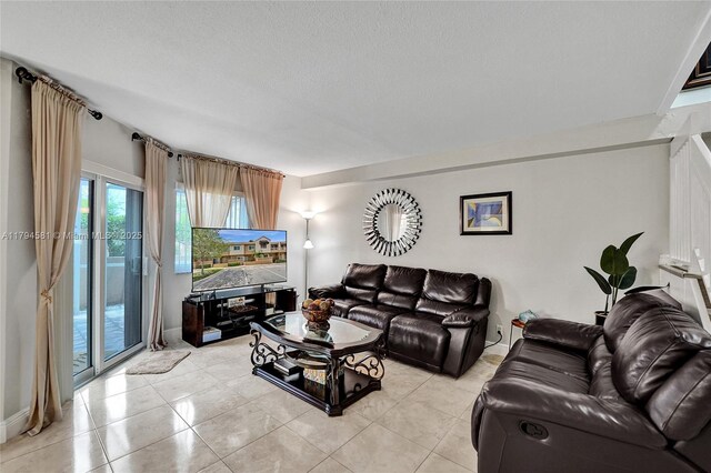 living room with a textured ceiling and light tile patterned floors
