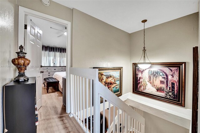 hallway featuring an upstairs landing and wood finished floors