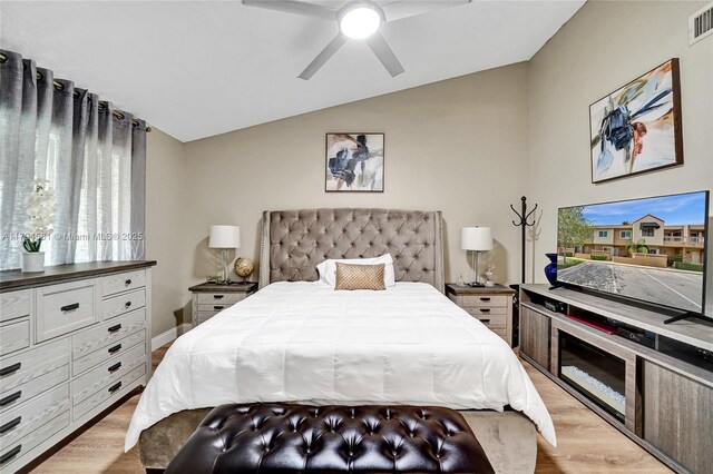 bedroom with ceiling fan, visible vents, light wood-style flooring, and lofted ceiling