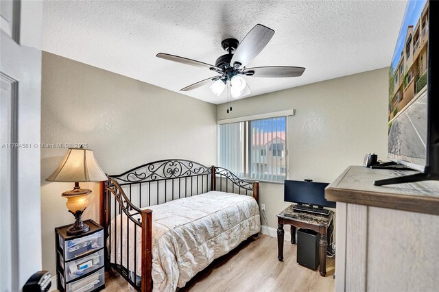 bedroom with baseboards, a ceiling fan, a textured ceiling, and wood finished floors