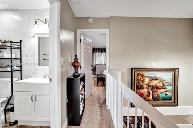 bathroom featuring vanity, wood finished floors, and tile walls