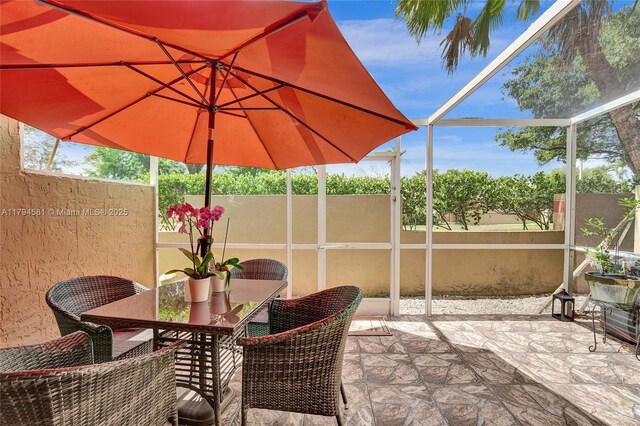 view of patio with fence and a lanai