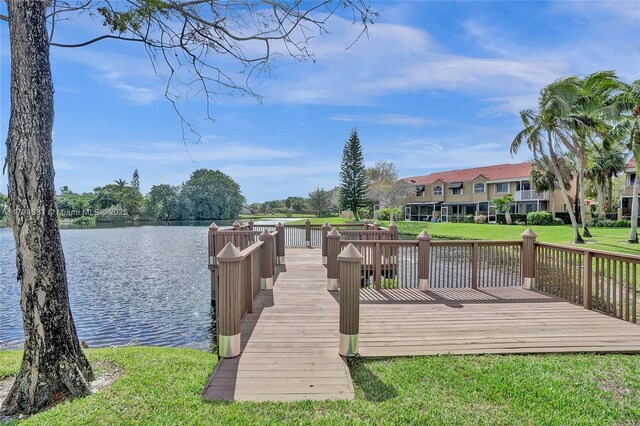 dock area featuring a lawn and a water view