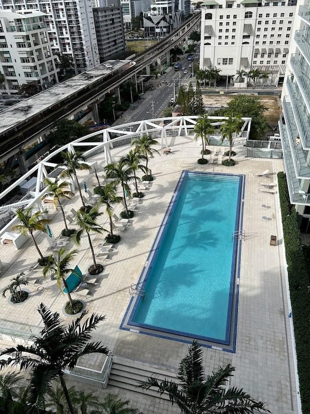 community pool with a city view and a patio
