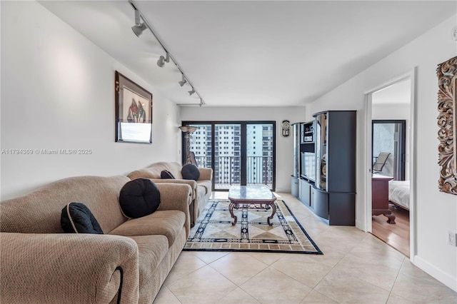 living area featuring rail lighting and light tile patterned floors