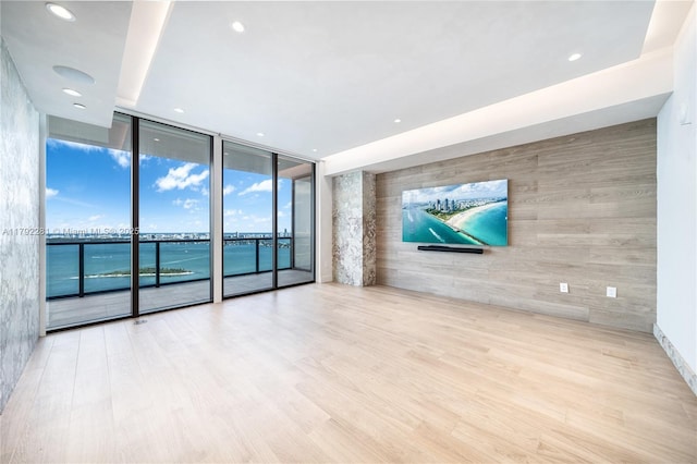 empty room with recessed lighting, a wall of windows, and wood finished floors