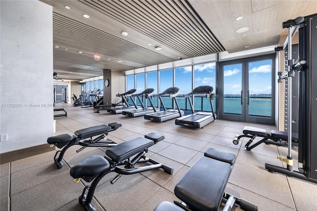 workout area featuring a water view, recessed lighting, wooden ceiling, and french doors