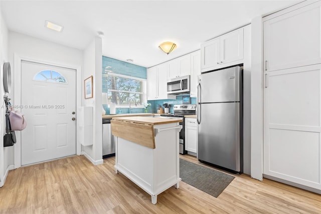 450 SE 7th St Unit 234, Dania Beach, FL 33004 - kitchen featuring white cabinetry, appliances with stainless steel finishes, wooden counters, and light wood finished floors