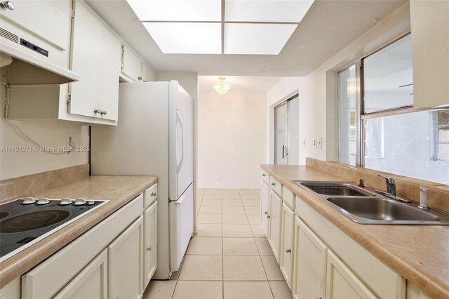 5810 NW 82nd Ter, Tamarac, FL 33321 - kitchen featuring a sink, under cabinet range hood, black electric cooktop, light tile patterned flooring, and light countertops