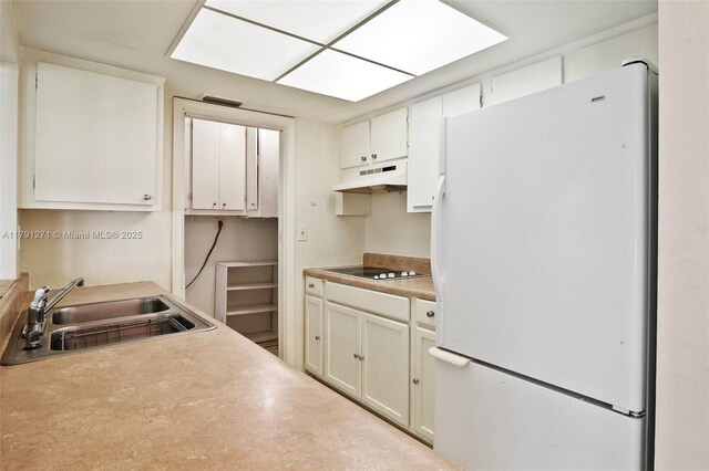5810 NW 82nd Ter, Tamarac, FL 33321 - kitchen featuring freestanding refrigerator, under cabinet range hood, a sink, white cabinetry, and light countertops