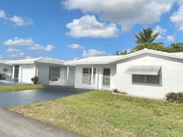 5810 NW 82nd Ter, Tamarac, FL 33321 - ranch-style house with stucco siding, a front lawn, and a garage