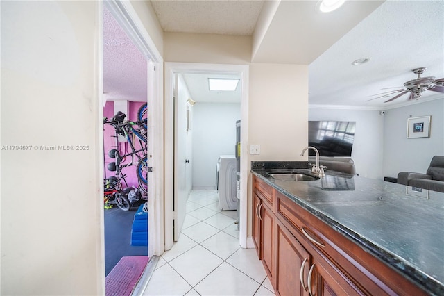 7354 NW 49th Ct, Lauderhill, FL 33319 - kitchen featuring brown cabinets, a sink, open floor plan, washer / dryer, and light tile patterned floors