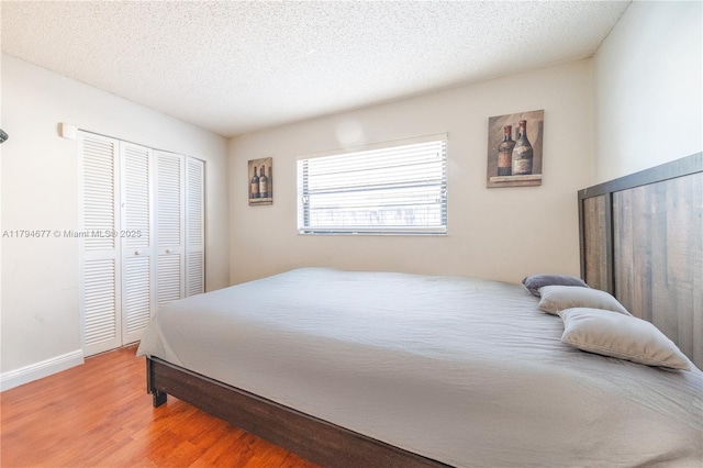 7354 NW 49th Ct, Lauderhill, FL 33319 - bedroom with a textured ceiling, baseboards, a closet, and wood finished floors