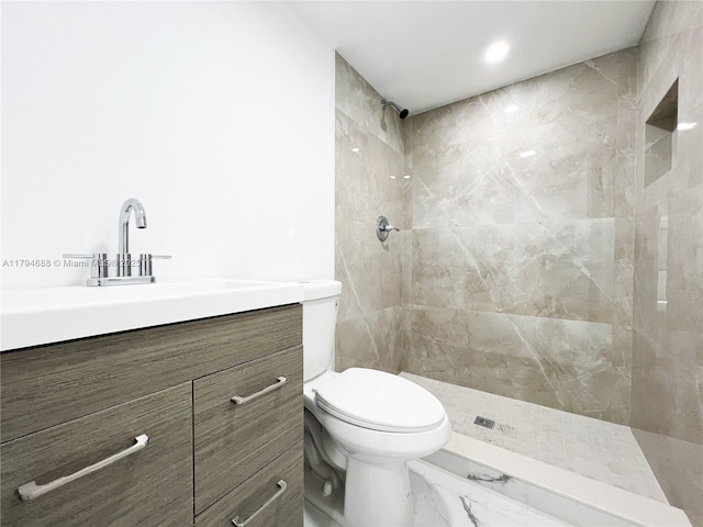 bathroom with vanity, marble finish floor, a tile shower, and toilet