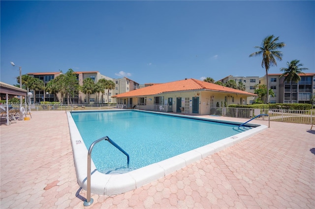 pool featuring fence and a patio area