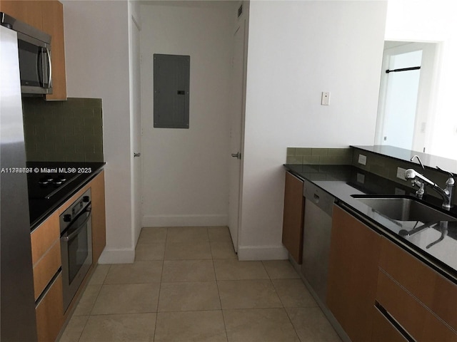 kitchen featuring electric panel, dark countertops, tasteful backsplash, a sink, and stainless steel appliances