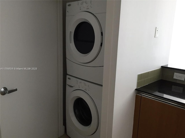 laundry room with stacked washing maching and dryer and laundry area