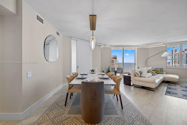 701 Brickell Key Blvd Unit 1812, Miami, FL 33131 - dining room featuring baseboards, visible vents, and wood finished floors