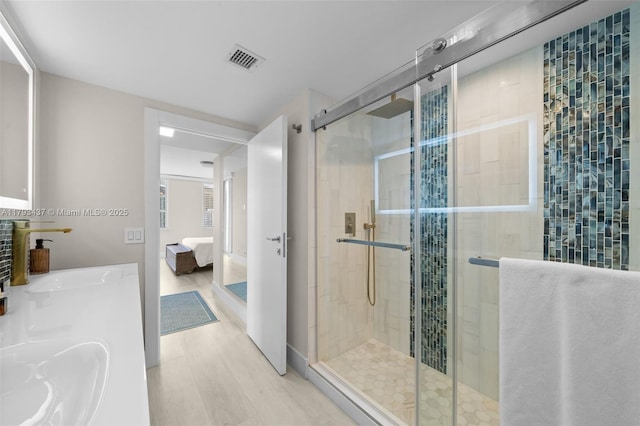 701 Brickell Key Blvd Unit 1812, Miami, FL 33131 - ensuite bathroom with visible vents, double vanity, wood finished floors, ensuite bathroom, and a shower stall