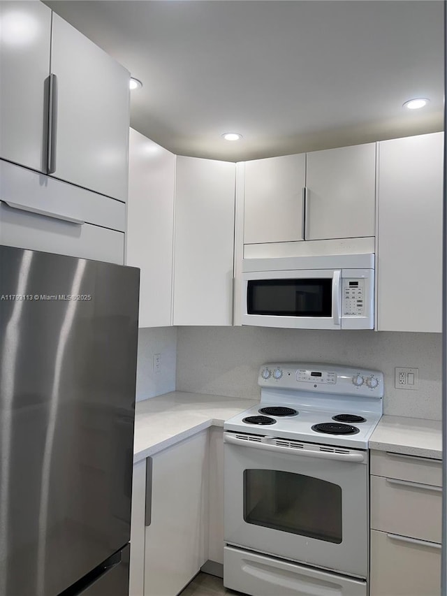 400 N Riverside Dr Unit 512, Pompano Beach, FL 33062 - kitchen with white appliances, light countertops, white cabinets, recessed lighting, and modern cabinets
