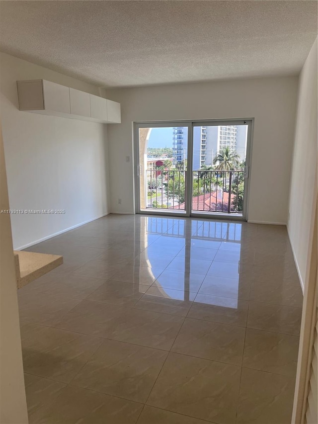 400 N Riverside Dr Unit 512, Pompano Beach, FL 33062 - unfurnished room with a textured ceiling, tile patterned flooring, and baseboards