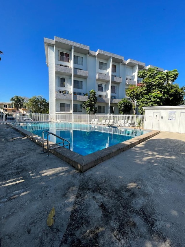 pool with a patio and fence