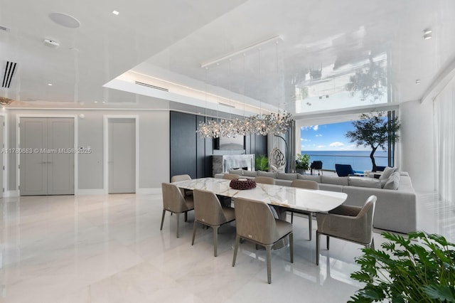 dining area with visible vents, marble finish floor, and a towering ceiling