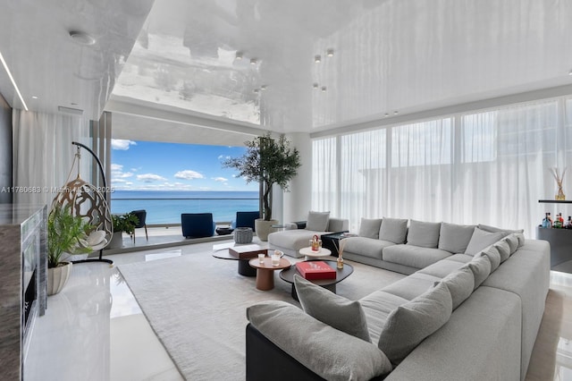 living room featuring a water view and a high ceiling