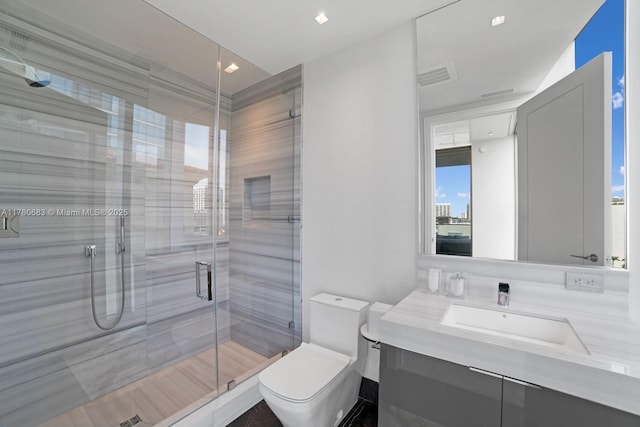full bathroom featuring toilet, visible vents, a shower stall, and vanity