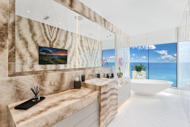 full bathroom with vanity, tile patterned floors, tile walls, visible vents, and a soaking tub
