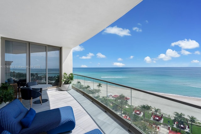 balcony with a water view and a view of the beach
