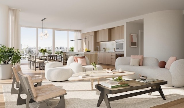 living room featuring a chandelier, expansive windows, and light wood-type flooring