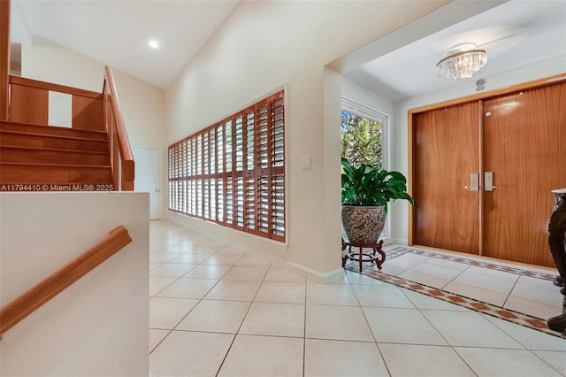 tiled entrance foyer with baseboards, stairway, an inviting chandelier, and recessed lighting