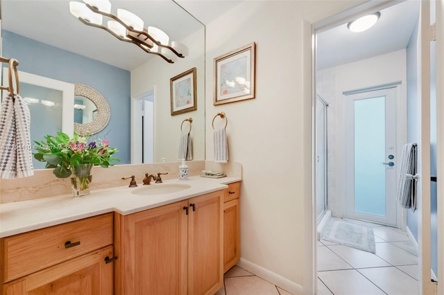 bathroom featuring baseboards, a shower stall, tile patterned flooring, and vanity
