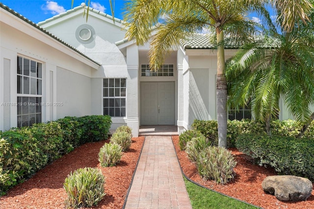 4629 Mariners Cove Dr, Wellington, FL 33449 - property entrance featuring stucco siding, a tiled roof, and an attached garage