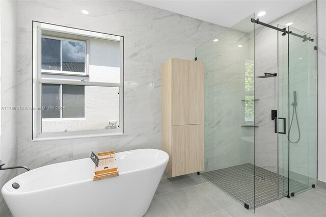 4629 Mariners Cove Dr, Wellington, FL 33449 - bathroom featuring tile walls, a marble finish shower, a soaking tub, and tile patterned floors