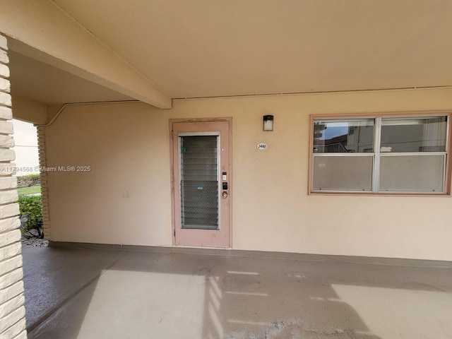property entrance featuring a patio and stucco siding