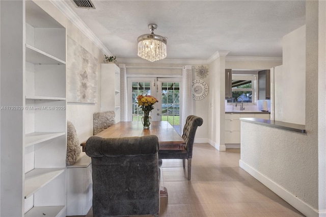 11450 NW 45th Pl, Sunrise, FL 33323 - dining room with crown molding, a notable chandelier, baseboards, wood finished floors, and visible vents