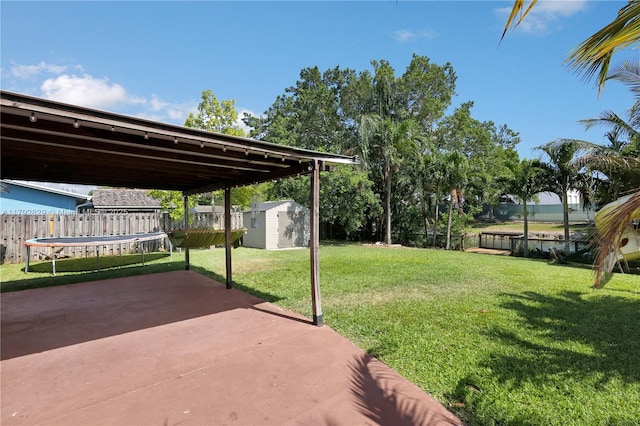 11450 NW 45th Pl, Sunrise, FL 33323 - view of yard with a trampoline, a storage shed, a fenced backyard, a patio area, and an outdoor structure