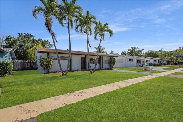 11450 NW 45th Pl, Sunrise, FL 33323 - view of front of home featuring fence, stucco siding, and a front yard