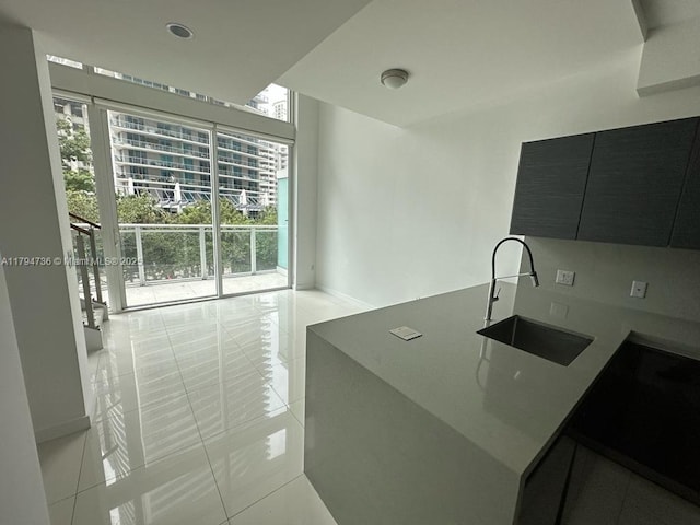 kitchen featuring a sink, floor to ceiling windows, modern cabinets, and light tile patterned flooring