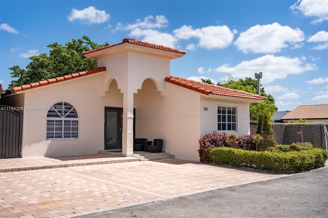 exterior space featuring a patio, a tiled roof, and stucco siding