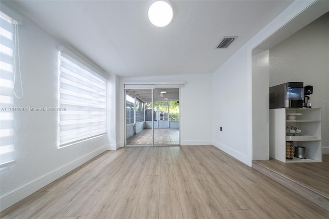 interior space with visible vents, baseboards, and wood finished floors