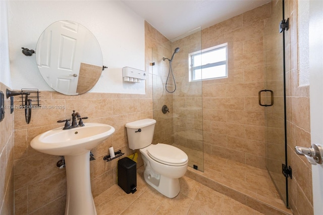 full bathroom featuring toilet, tile walls, a shower stall, and tile patterned flooring